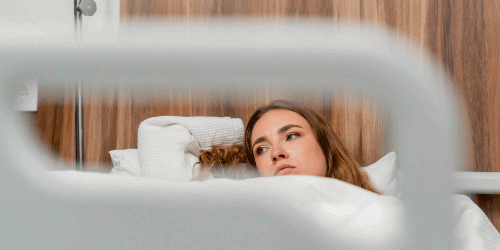 SURNE-Bajas-empleados-clave-de-empresas Mujer joven pensativa en la cama de un hospital